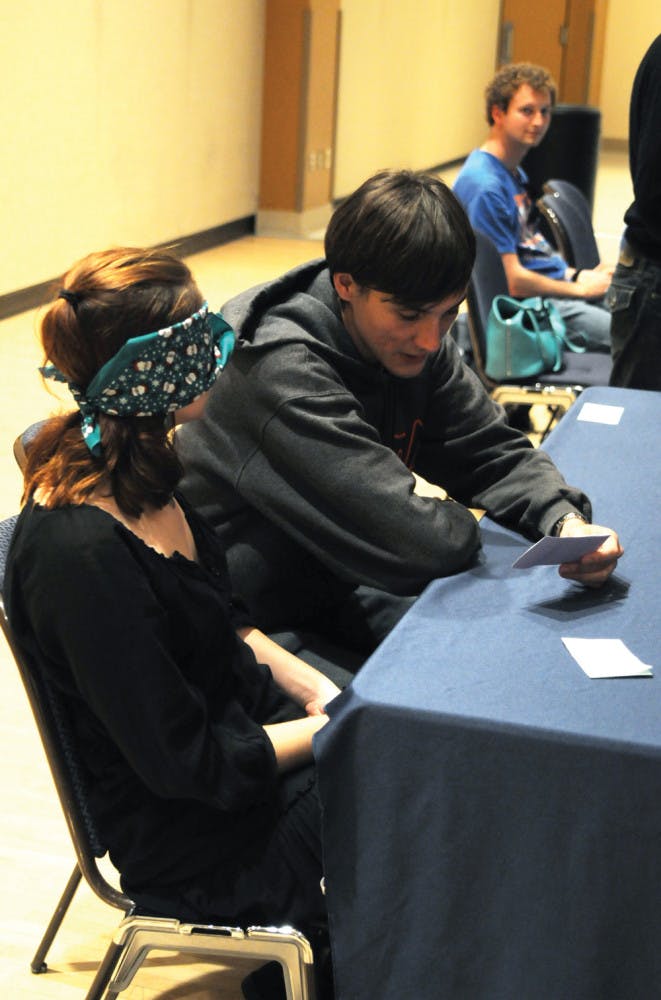 UF materials science and engineering junior Matt Wener, 21, wears earplugs and assists UF English senior Constance Hackler, 20, who wears a blindfold as part of the Dining with Disabilities event in the Reitz Union Rion Ballroom on Monday evening. Participants were challenged with an assigned disability to gain a better understanding of others’ lifestyles.