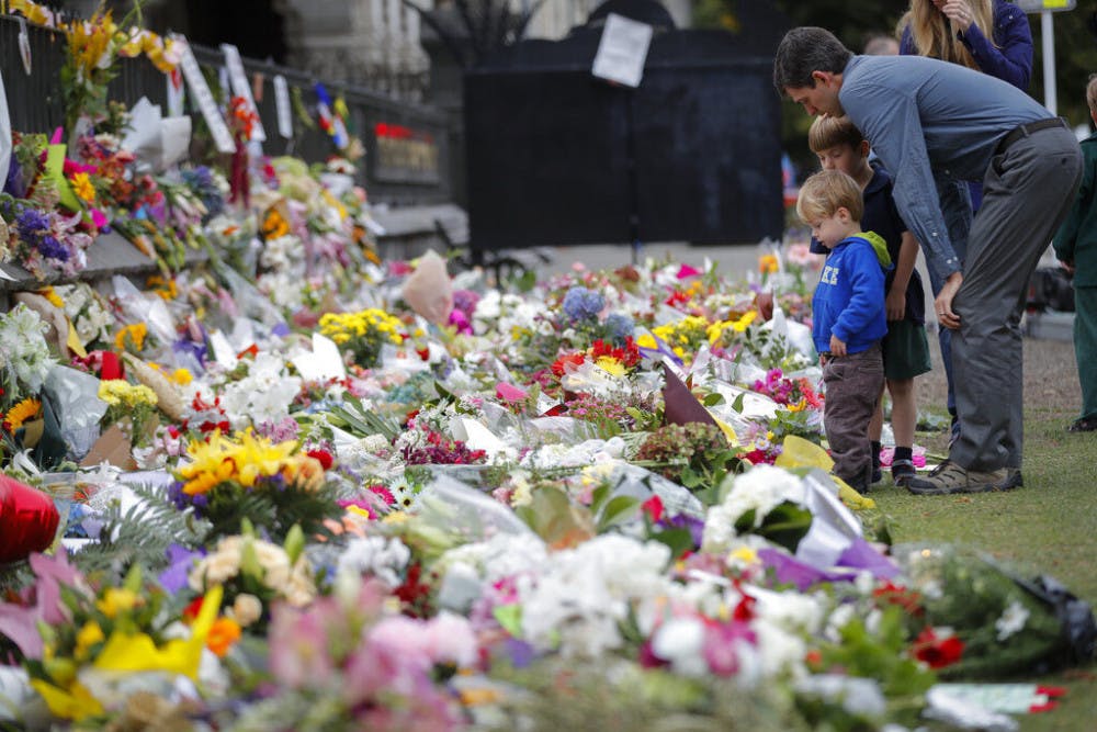 Mourners lay flowers on a wall at the Botanical Gardens in Christchurch, New Zealand, Monday, March 18, 2019. A steady stream of mourners paid tribute at makeshift memorial to the 50 people slain by a gunman at two mosques in Christchurch, while dozens of Muslims stood by to bury the dead when authorities finally release the victims' bodies. (AP Photo/Vincent Thian)