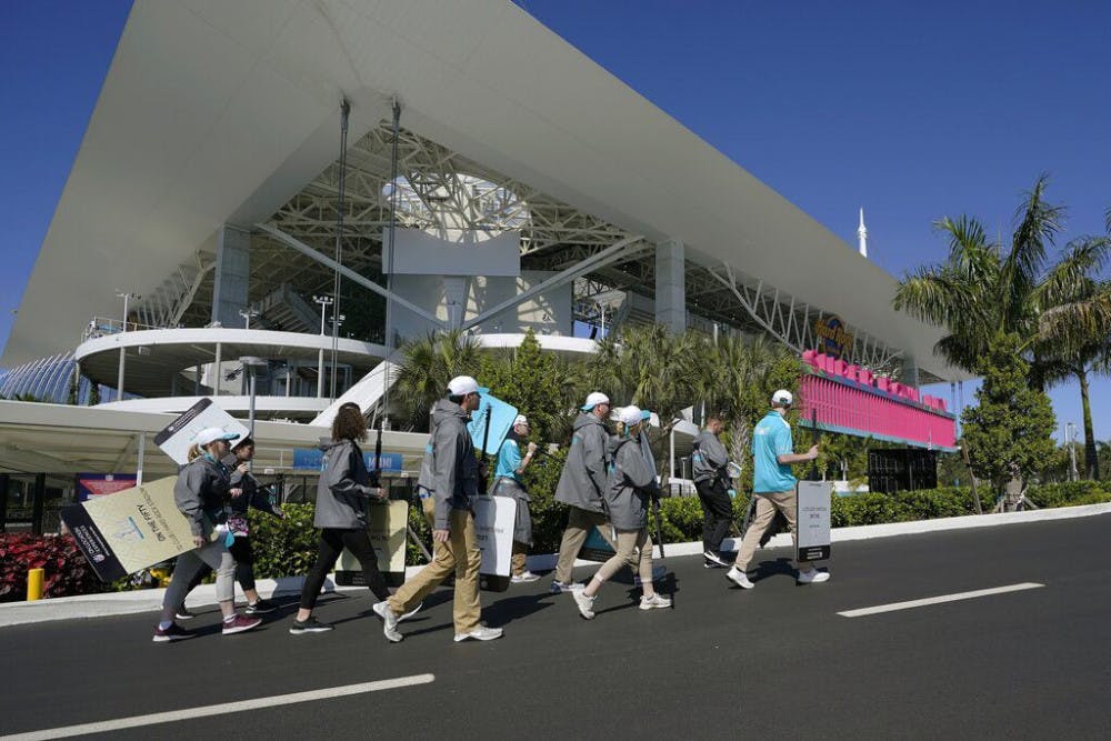 Workers arrive outside of the Hard Rock Stadium before the NFL Super Bowl 54 football game between the San Francisco 49ers and the Kansas City Chiefs, Sunday, Feb. 2, 2020, in Miami. (AP Photo/David J. Phillip)