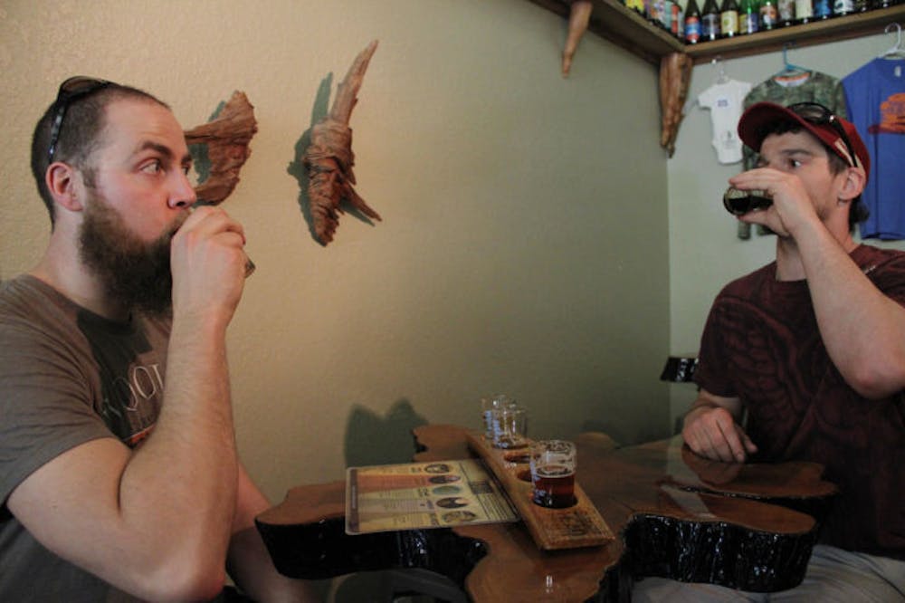 <p class="p1">Sam Linhoff, 29, and Jake Lehn, 29, drink beer at Swamp Head Brewery on Monday afternoon.​ The brewery won a gold medal for its smoke beer, Smoke Signal, on Friday at the World Beer Cup.</p>