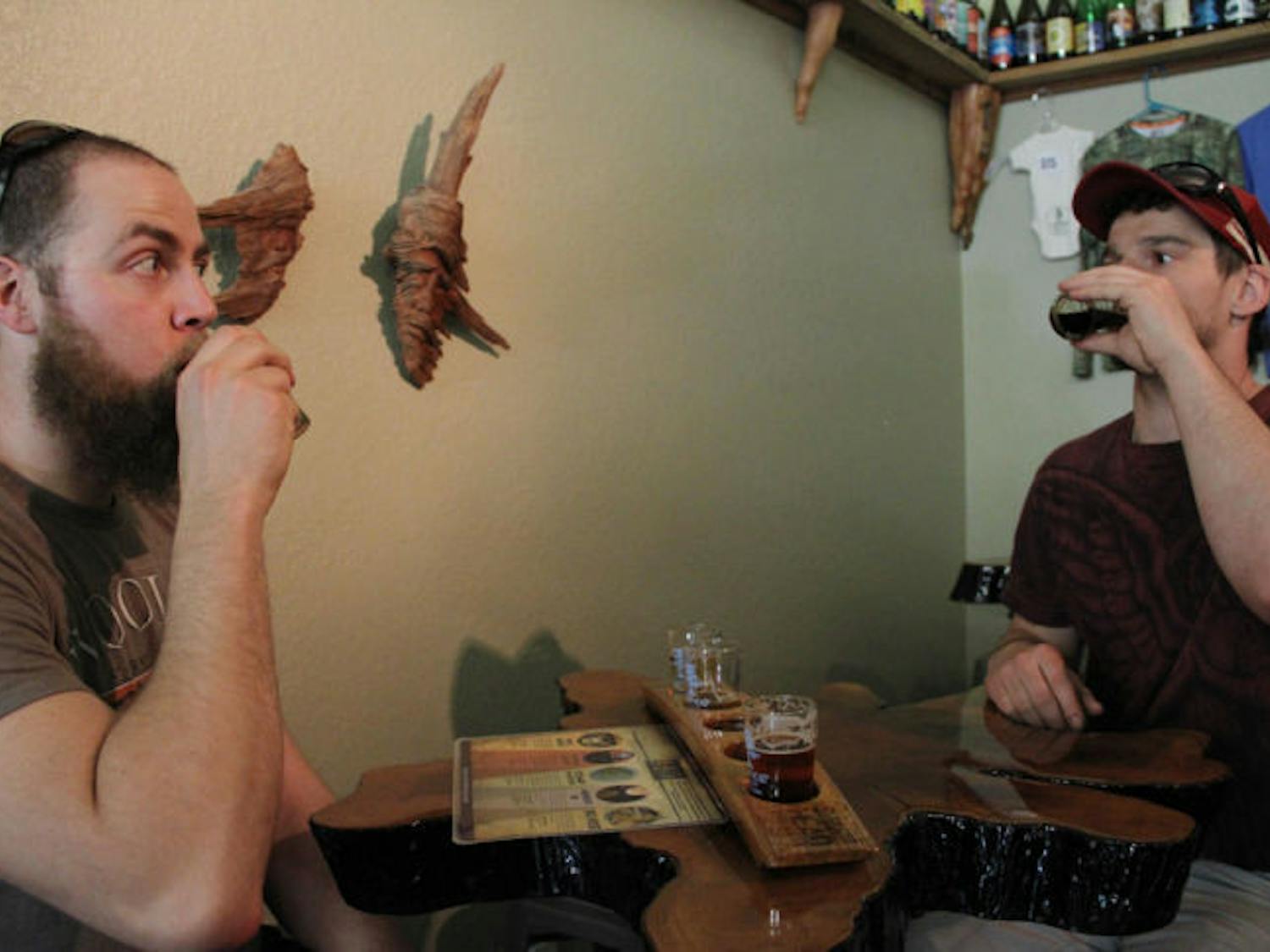 Sam Linhoff, 29, and Jake Lehn, 29, drink beer at Swamp Head Brewery on Monday afternoon.​ The brewery won a gold medal for its smoke beer, Smoke Signal, on Friday at the World Beer Cup.