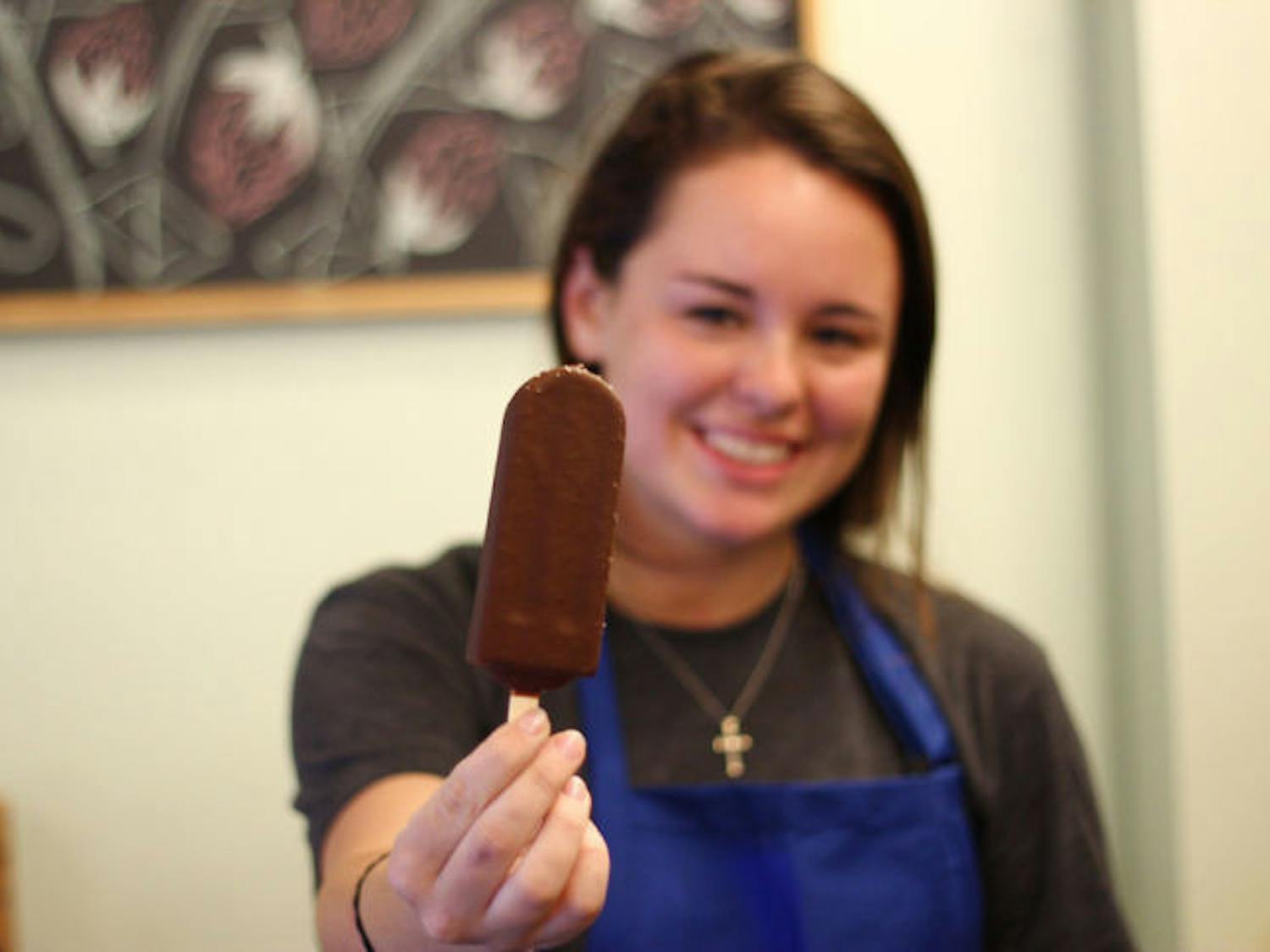 Nicole Giaquinto, a 20-year-old UF public relations sophomore, displays a chocolate-covered ice pop at The Hyppo Gourmet Ice Pops on Monday evening. The Hyppo opened its doors for the first time this weekend.&nbsp;