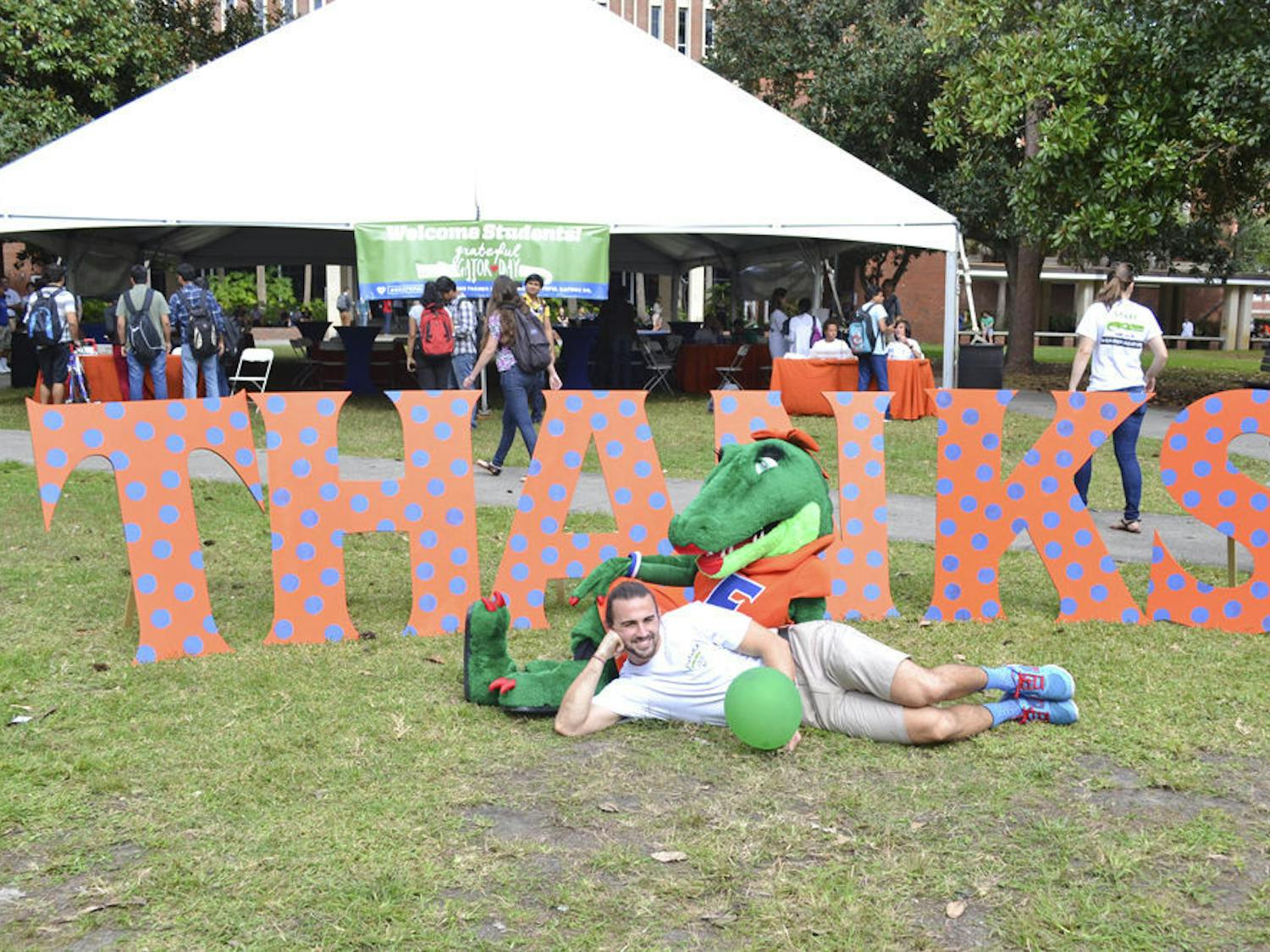 It was the week before Thanksgiving, but several hundred UF students gave thanks Wednesday morning during the first-ever Grateful Gator Day.
Students thanked about 30,000 UF donors on the Plaza of the Americas by writing about 1,000 handwritten orange cards, video-taping their Gator Chomps and posing for photos with a giant, polka-dotted "THANKS." The event served to make students aware of how much money people donate to the university, said Kevin Marfiak, a 23-year-old UF biology senior and Cicerone who helped plan the event.