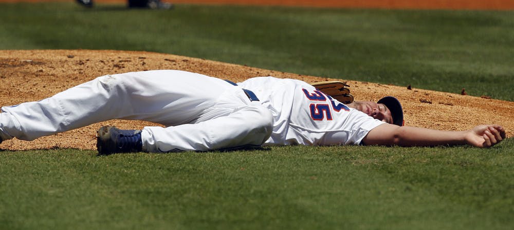 Florida's Brian Johnson lies on the ground after being hit by a throw to second from catcher Mike Zunino in the first inning in the Gators 4-3 loss to Georgia in the SEC Tournament semifinals Saturday in Hoover, Ala.