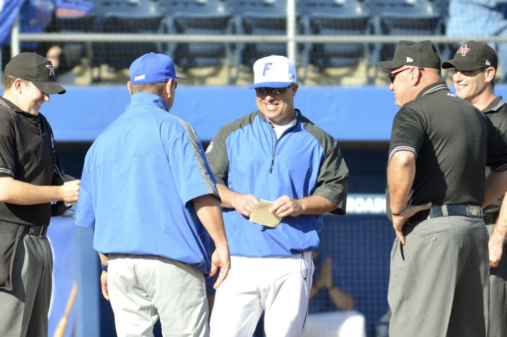 UF coach Kevin O'Sullivan meets with the opposing team's manager before Florida's 8-4 win over FGCU on Feb. 20, 2016, at McKethan Stadium.