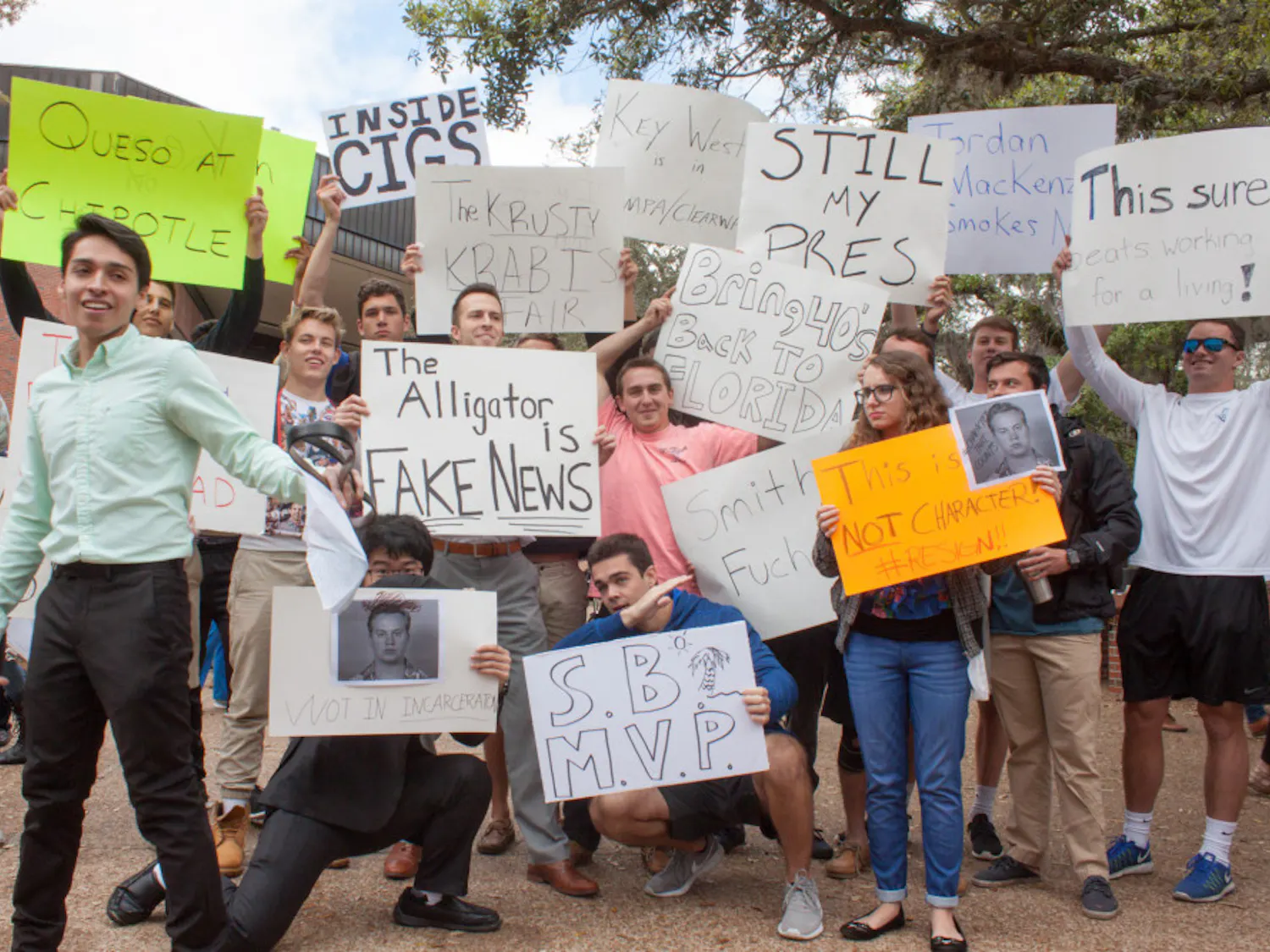 Anthony Rojas (front), a 21-year-old third-year political science major who organized the protest against student body president Smith Myers, tries to speak to a crowd while counter-protesters hold signs behind him and other protesters.