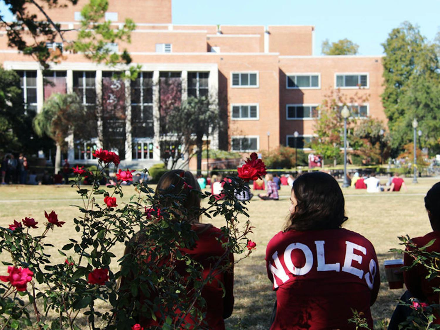 Three FSU students sit on Landis Green Thursday and face Strozier Library.