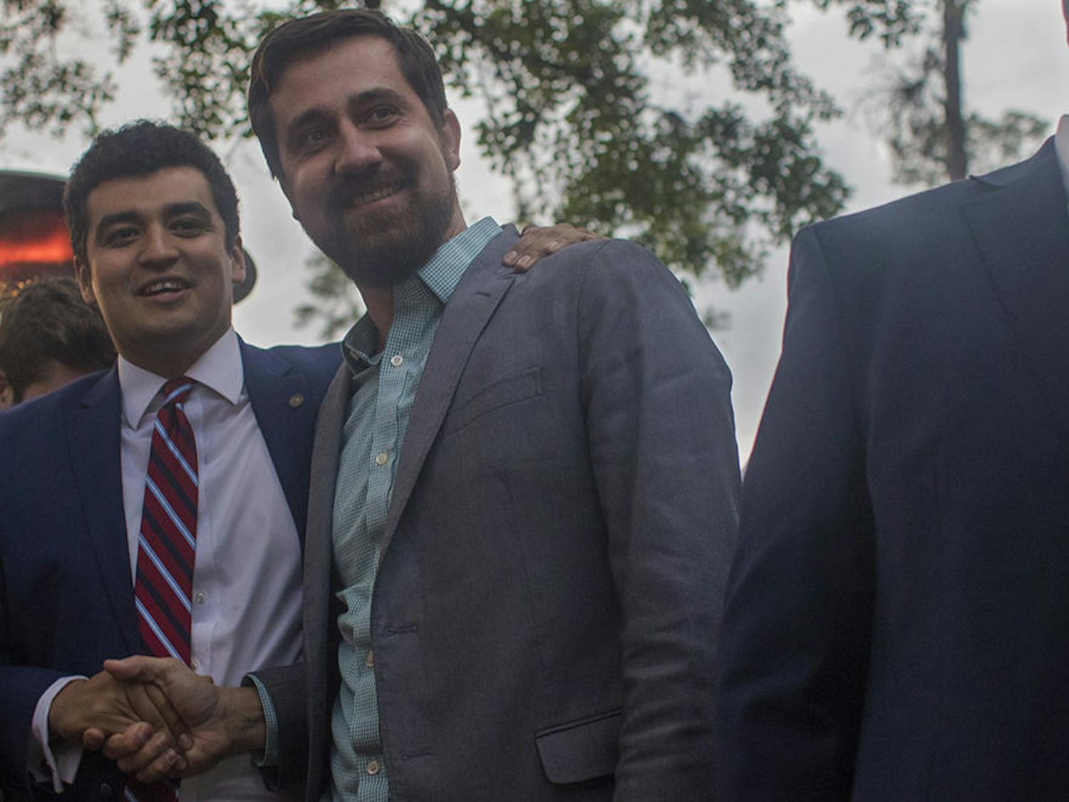 Adrian Hayes-Santos shakes City Commissioner David Arreola’s hand Tuesday during Hayes-Santos and Lauren Poe’s watch party at the Public and General restaurant. Hayes-Santos beat Robert Mounts to become Gainesville city commissioner for District 4.
