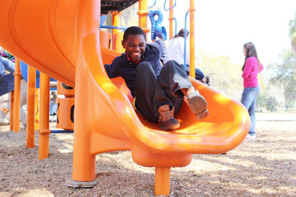 <p>Woodrow, 10, slides on the playground at the Woodland Park campus of the Alachua County Boys and Girls Club. It earned the National Honor Award for Program Excellence.</p>