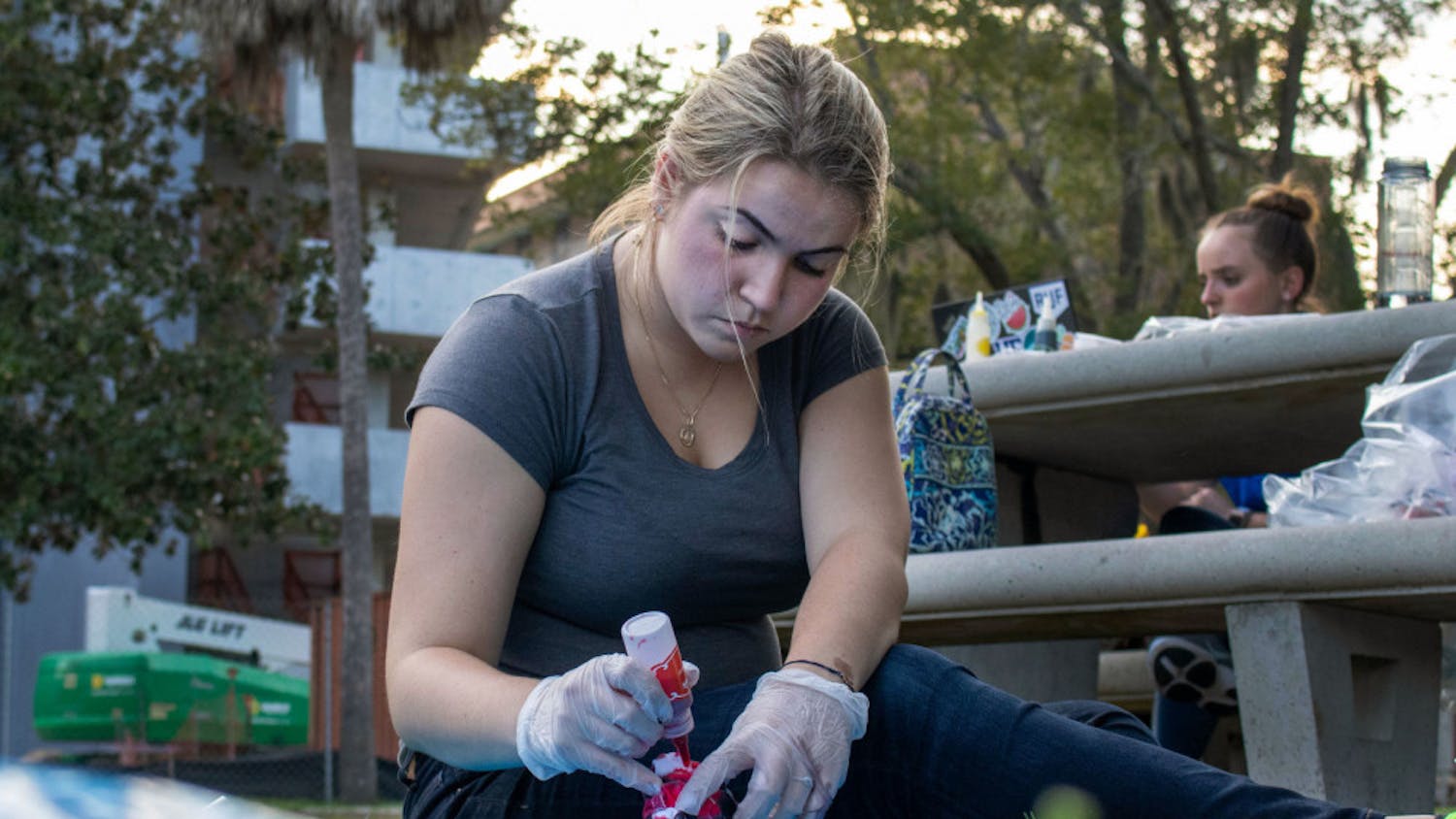 Andrea Lopez, an 18-year-old biomedical engineering freshman at the University of Florida, tie-dyes a shirt Thursday evening during an event for the SWEek of Welcome on the Reitz North Lawn. Lopez said she heard about SWE during E-Swamp and decided she wanted to be a member.&nbsp;