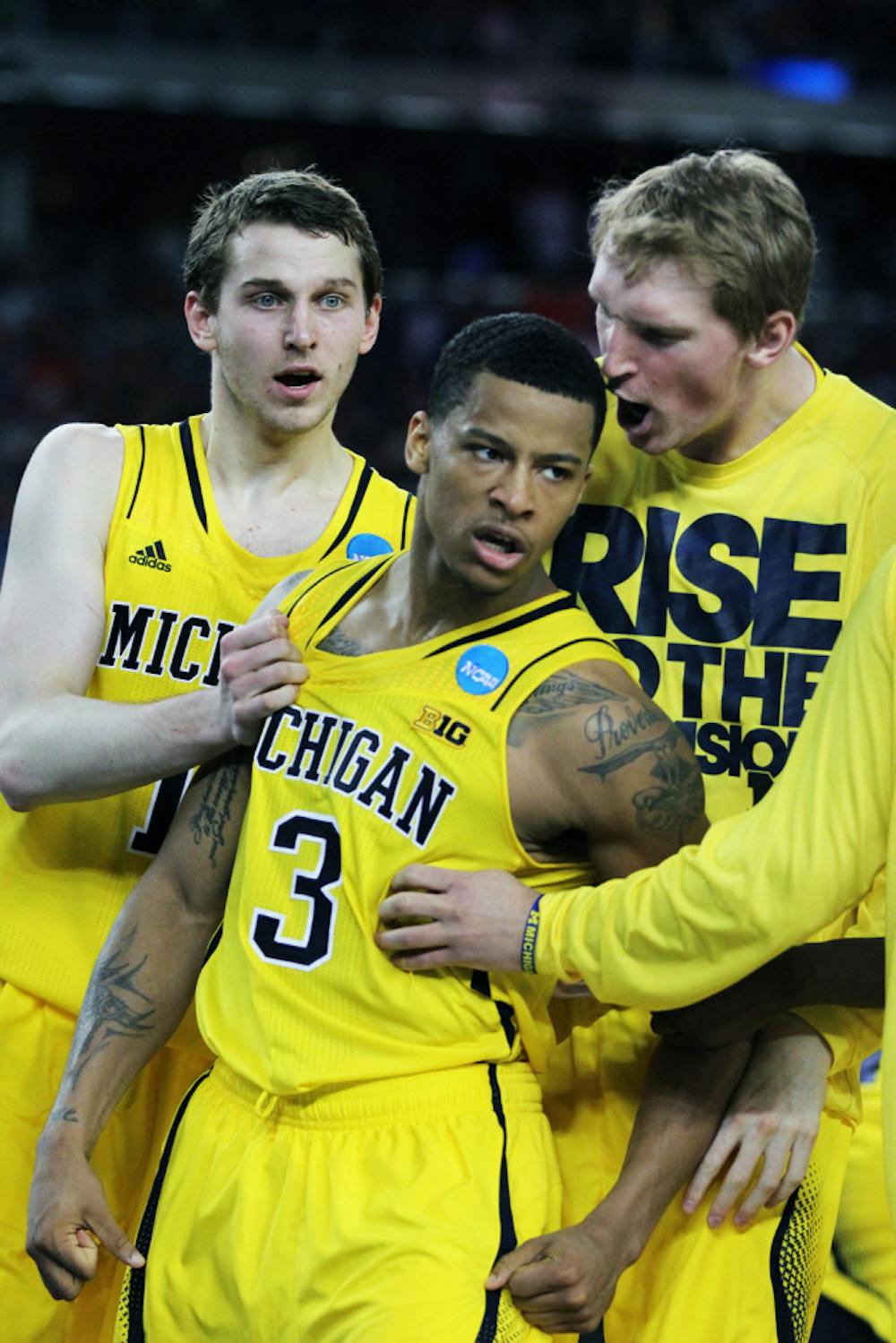 <p>Michigan guard Trey Burke (3) celebrates with his teammates after making a game-tying three pointer during the second half of Friday's Sweet 16 game against Kansas at Cowboys Stadium in Austin, Texas. The Wolverines defeated the Jayhawks 87-85 in overtime.</p>