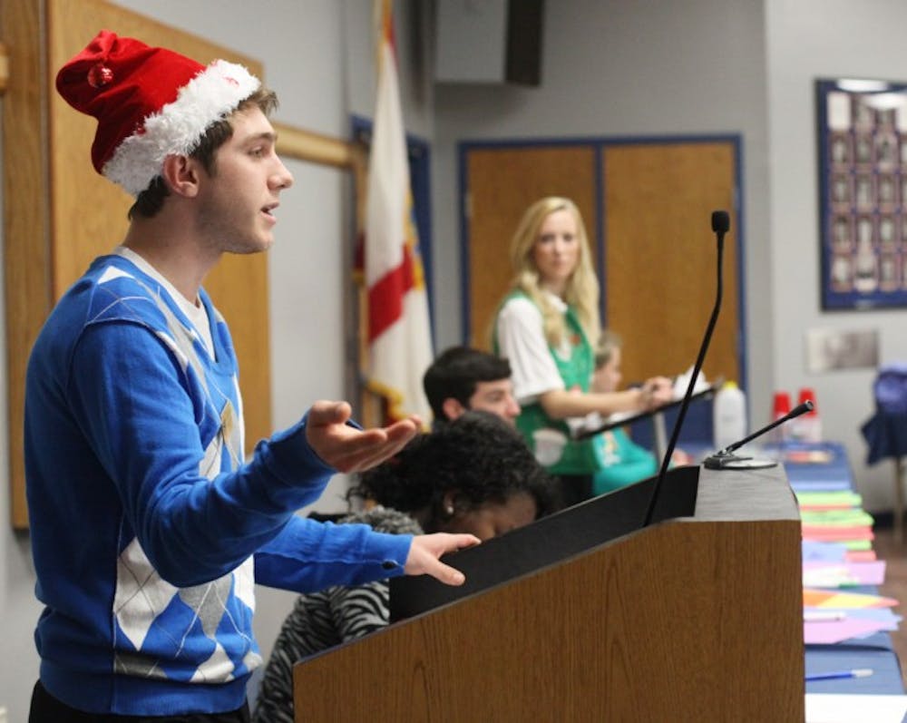 <p>Allocations Committee Chairman Elliot Grasso speaks Tuesday at the Student Senate’s tacky sweater-themed meeting.</p>