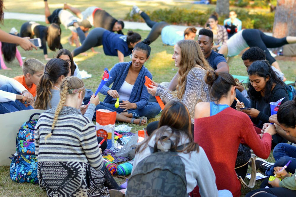 Students gather Thursday to make stress balls and unwind with a yoga session during the Member Leadership Program’s “Chomp the Stress” event on the Plaza of the Americas. Students were given free pizza, yoga and crafts to help them relax before final exams.