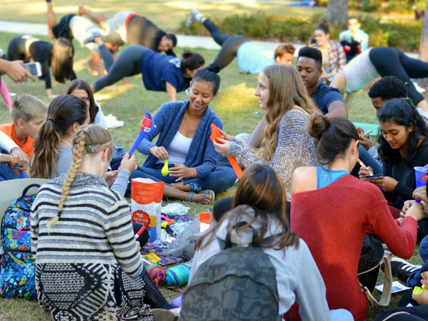 Students gather Thursday to make stress balls and unwind with a yoga session during the Member Leadership Program’s “Chomp the Stress” event on the Plaza of the Americas. Students were given free pizza, yoga and crafts to help them relax before final exams.