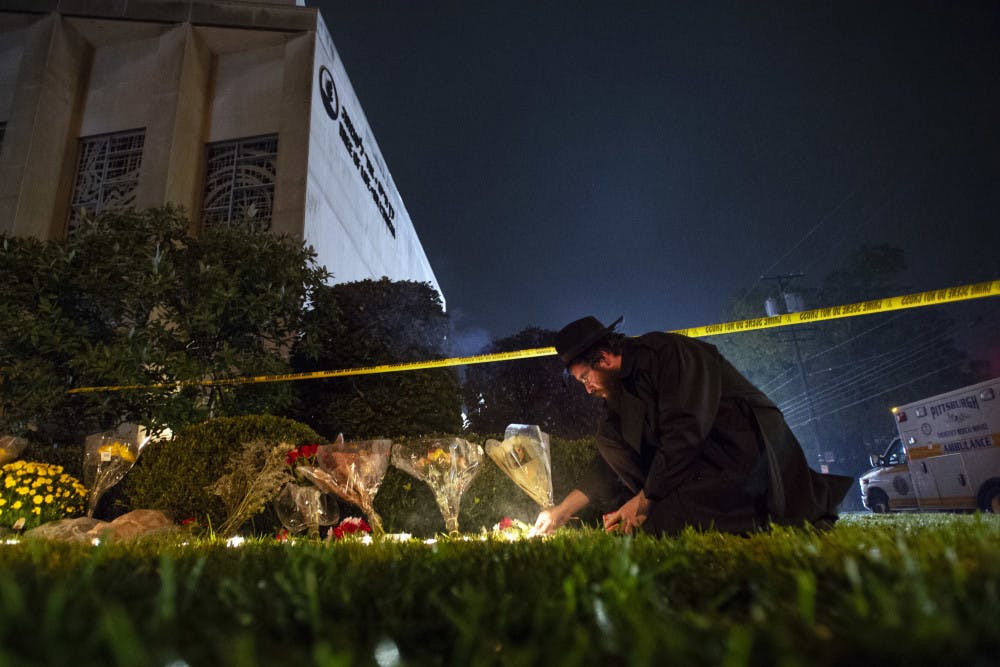 In this Oct. 27, 2018 photo, Rabbi Eli Wilansky lights a candle after a mass shooting at Tree of Life Synagogue in Pittsburgh's Squirrel Hill neighborhood. Robert Bowers, the suspect in Saturday's mass shooting, expressed hatred of Jews during the rampage and told officers afterward that Jews were committing genocide and he wanted them all to die, according to charging documents made public Sunday. (Steph Chambers/Pittsburgh Post-Gazette via AP)