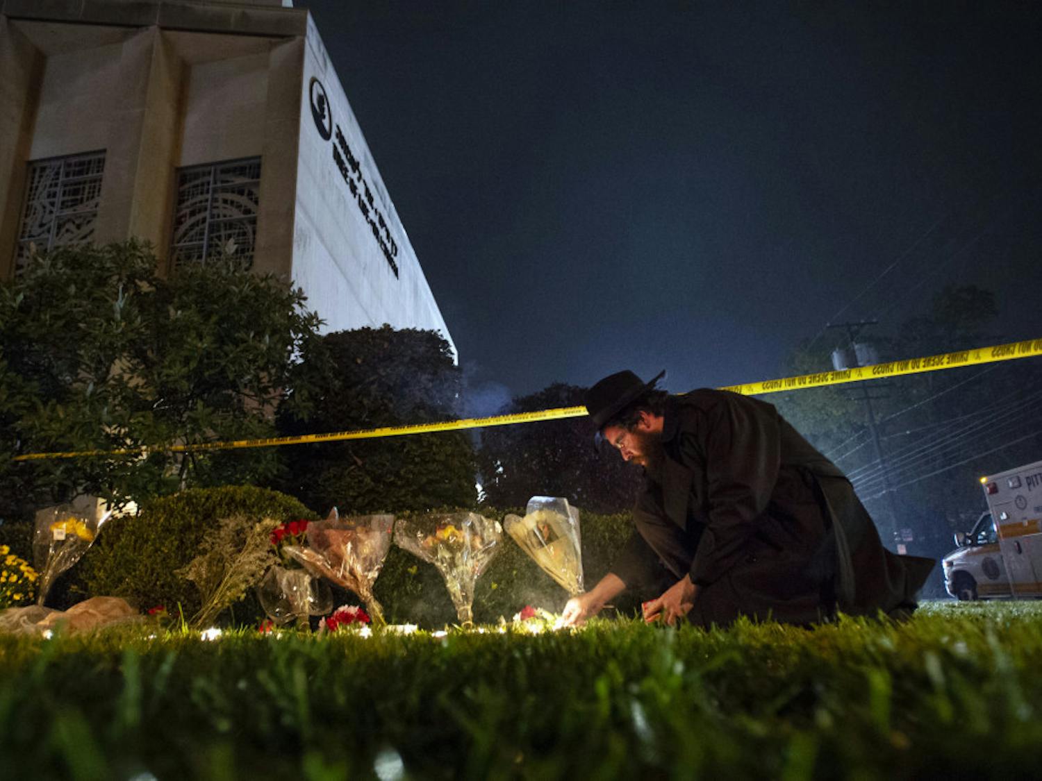 In this Oct. 27, 2018 photo, Rabbi Eli Wilansky lights a candle after a mass shooting at Tree of Life Synagogue in Pittsburgh's Squirrel Hill neighborhood. Robert Bowers, the suspect in Saturday's mass shooting, expressed hatred of Jews during the rampage and told officers afterward that Jews were committing genocide and he wanted them all to die, according to charging documents made public Sunday. (Steph Chambers/Pittsburgh Post-Gazette via AP)