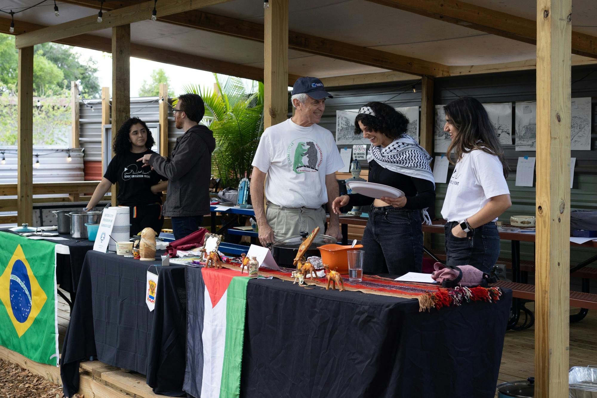 People work tables adorned with the flags of Brazil and Palestine during the Taste the World International Food Festival at First Magnitude Brewing Company on Saturday, March 23, 2024.