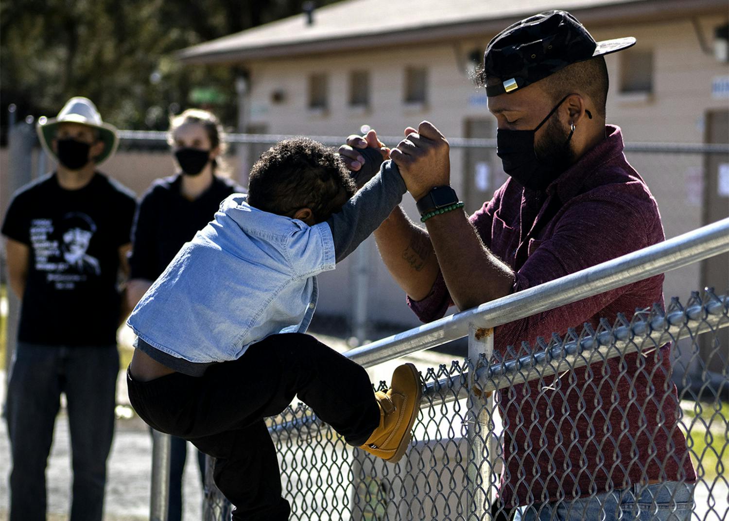 Ryan Hope Travis helps his 2-year-old son, Rezen Hope Travis, climb a fence at the King Celebration at Citizens Field on Monday, Jan. 18, 2021. Ryan Hope Travis said it was the first Martin Luther King Jr. Day celebration Rezen was old enough to understand. “Him knowing his history is the foundation of him being able to grow,” he said. 