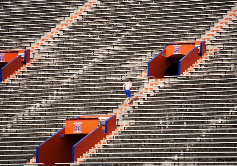 <p>A man run stadiums in order to stay fit in Ben Hill Griffin Stadium on Aug. 10.</p>