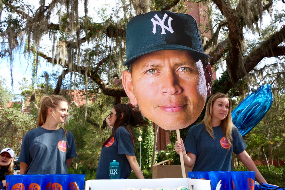Accent Speakers Bureau staff members, Alyssa Kobernick, 21, a UF political science senior, Samantha Winder, a 21-year-old UF psychology senior and Anne Redmond, a 22-year-old UF marketing senior, table at Turlington Plaza in celebration of Accent's 50-year anniversary and upcoming speaker Alex Rodriguez. 