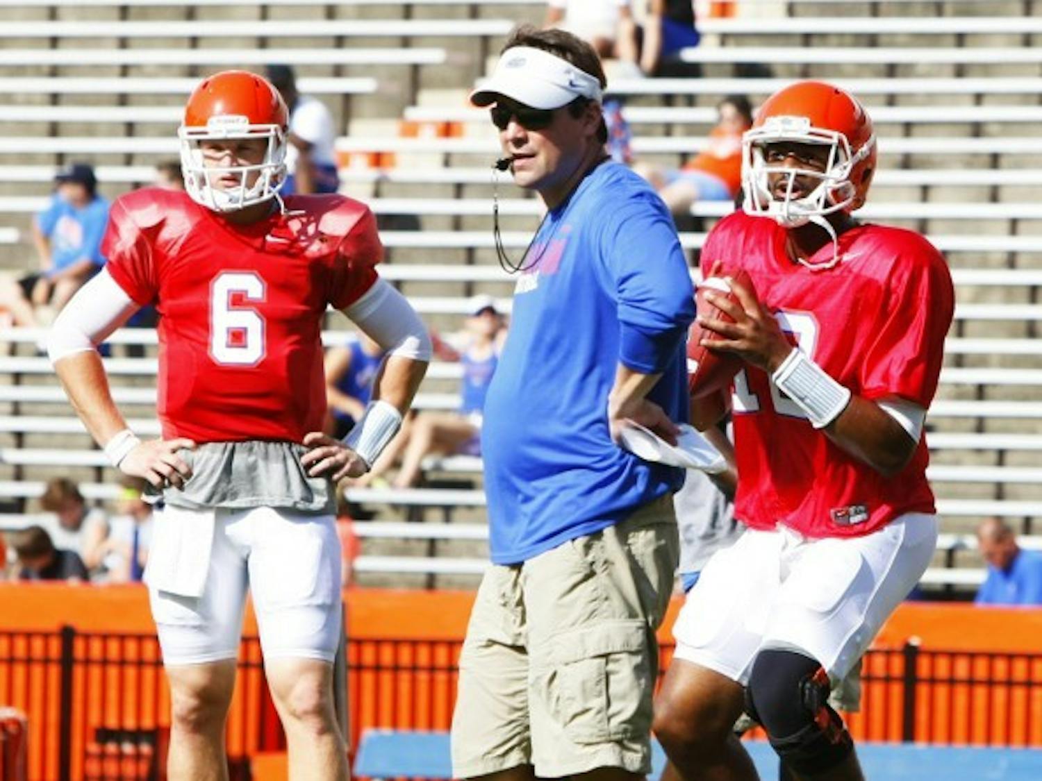 Coach Will Muschamp watches over practice while quarterback Jacoby Brissett (12) passes the ball and Jeff Driskel (6) waits his turn.