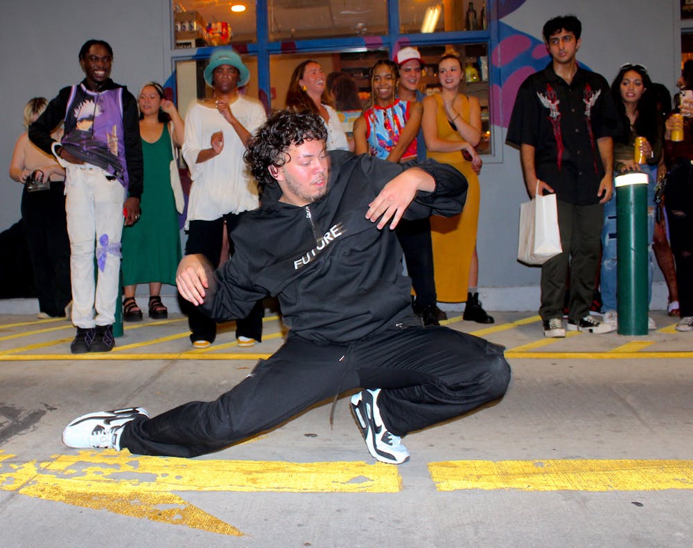 Local dancer Kevin Rodriguez, also known as Woahdizzy, gets down low at the How Bazar block party on Friday, Aug. 25, 2023.