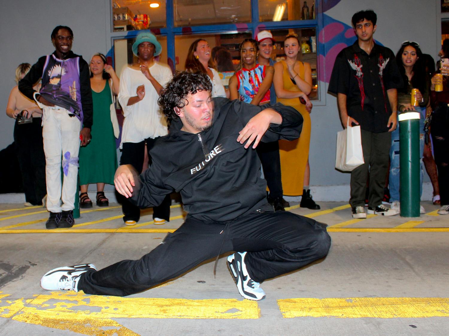Local dancer Kevin Rodriguez, also known as Woahdizzy, gets down low at the How Bazar block party on Friday, Aug. 25, 2023.
