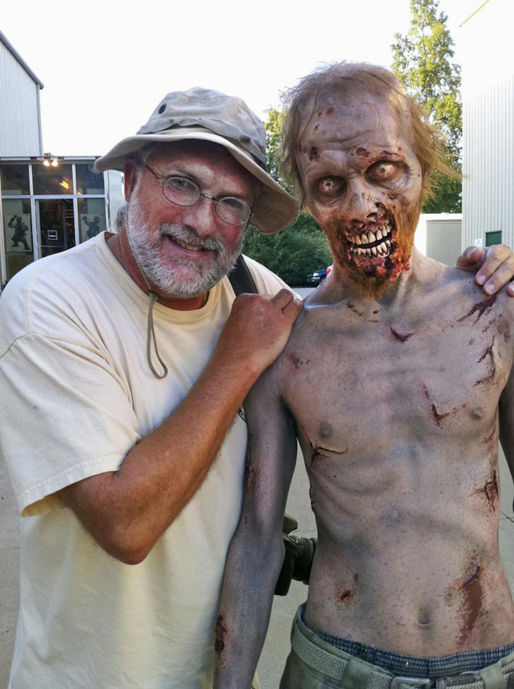 <p>University of Florida alumnus Gene Page, set photographer for "The Walking Dead" poses for a photo with one of the cast's zombies.</p>