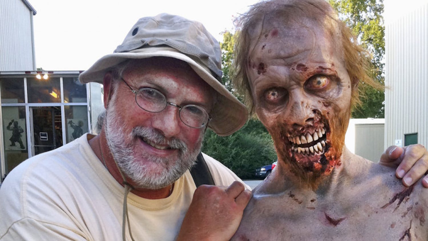 University of Florida alumnus Gene Page, set photographer for "The Walking Dead" poses for a photo with one of the cast's zombies.