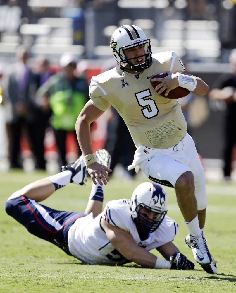 Central Florida quarterback Blake Bortles (5) runs past Connecticut defensive end Tim Willman, left, during UCF's 62-17 win in Orlando on Oct. 26.