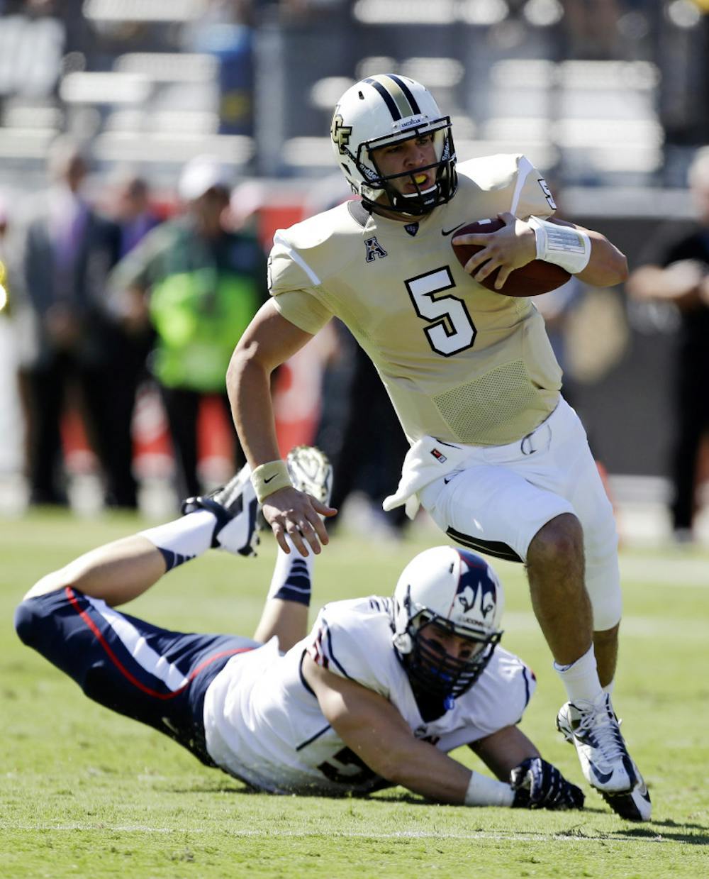<p>Central Florida quarterback Blake Bortles (5) runs past Connecticut defensive end Tim Willman, left, during UCF's 62-17 win in Orlando on Oct. 26.</p>