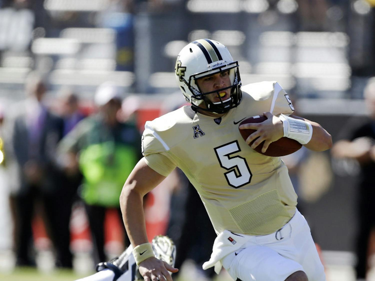 Central Florida quarterback Blake Bortles (5) runs past Connecticut defensive end Tim Willman, left, during UCF's 62-17 win in Orlando on Oct. 26.