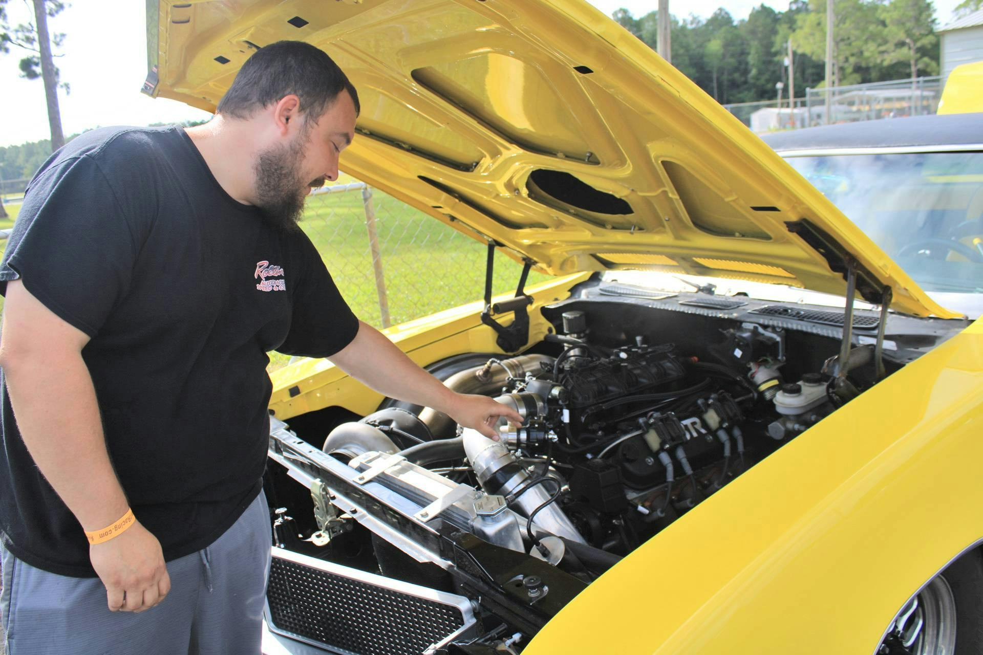 Michael Fair, 31, explains the engine of his Buick Skylark at the Gainesville Raceway on Saturday, July 15, 2023. 
