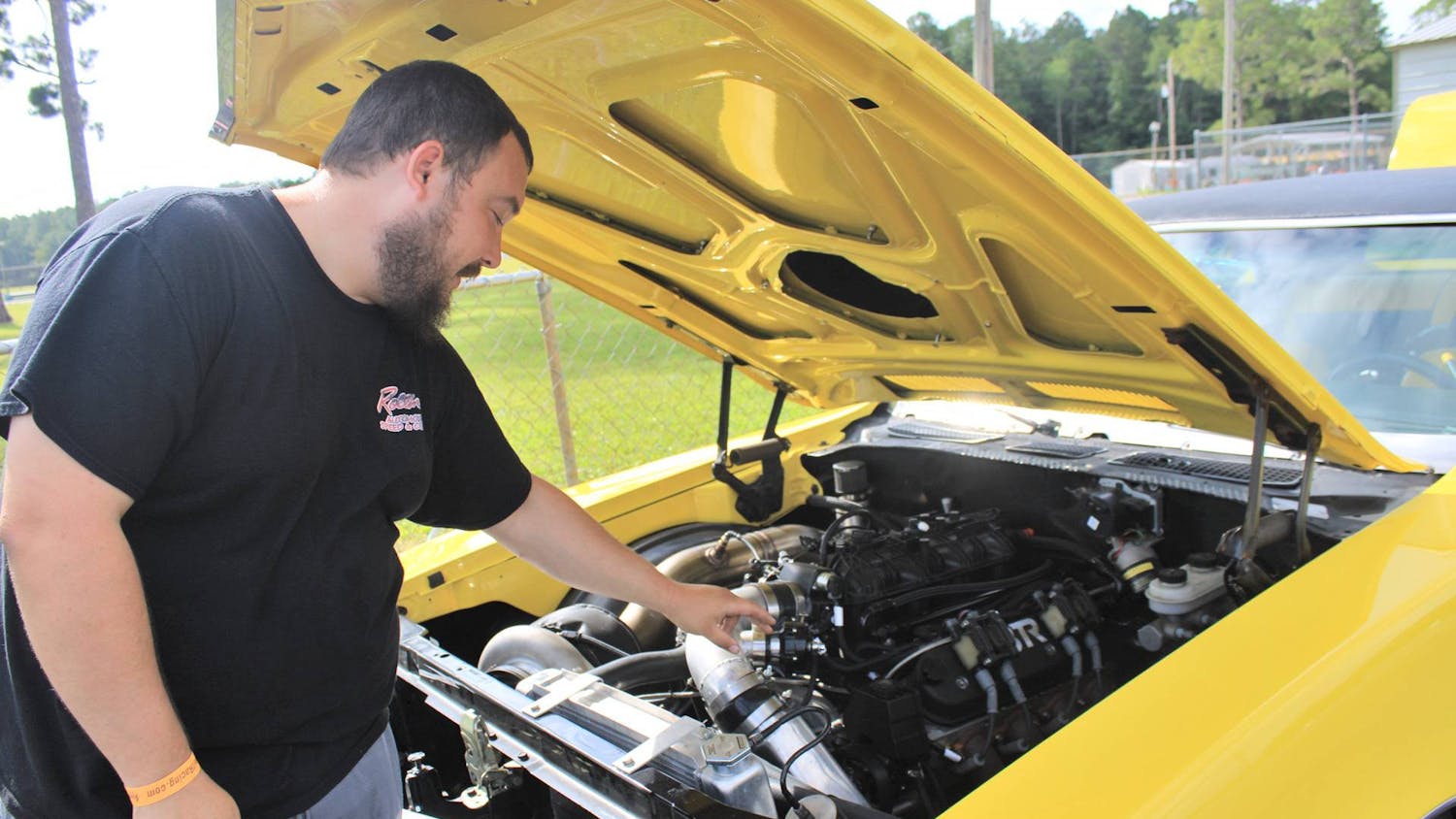 Michael Fair, 31, explains the engine of his Buick Skylark at the Gainesville Raceway on Saturday, July 15, 2023. 