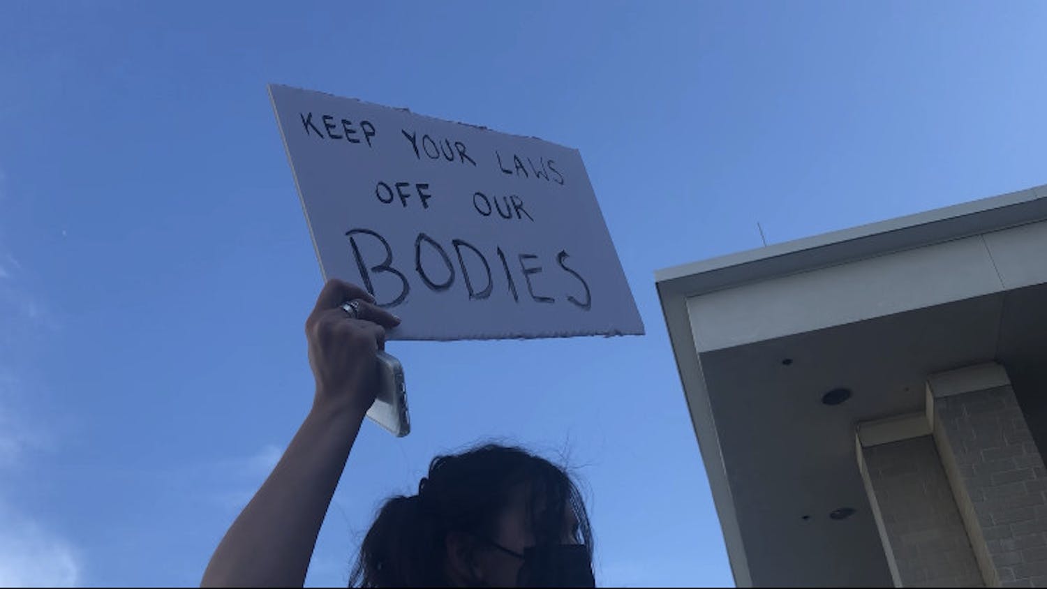 A protester hoists a sign in support of women&#x27;s rights to privacy and bodily autonomy at the Stephan P. Mickle, Sr. Criminal Courthouse on Tuesday, May 3. 