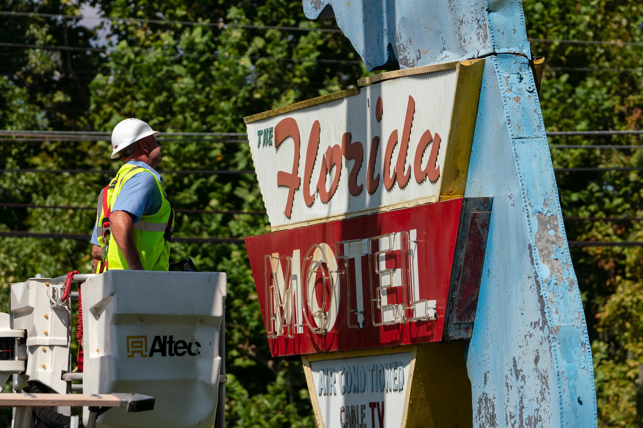 Construction workers dismantle the iconic Florida Motel sign on Southwest 13th Street Wednesday afternoon. It took six hours and a five-person crew.