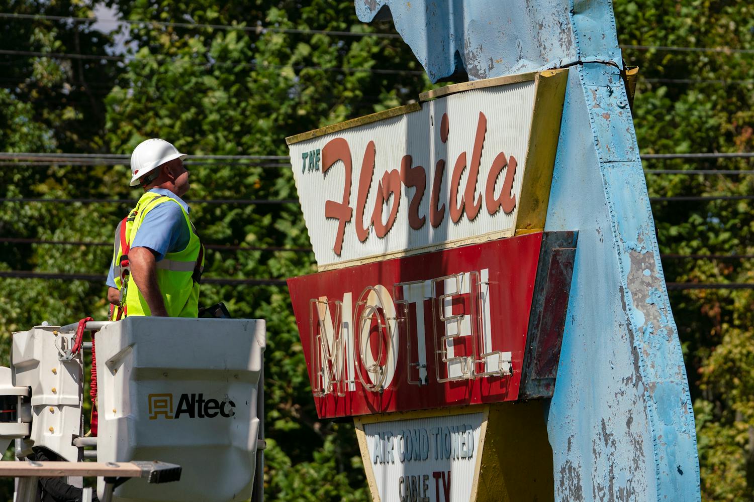 Construction workers dismantle the iconic Florida Motel sign on Southwest 13th Street Wednesday afternoon. It took six hours and a five-person crew.