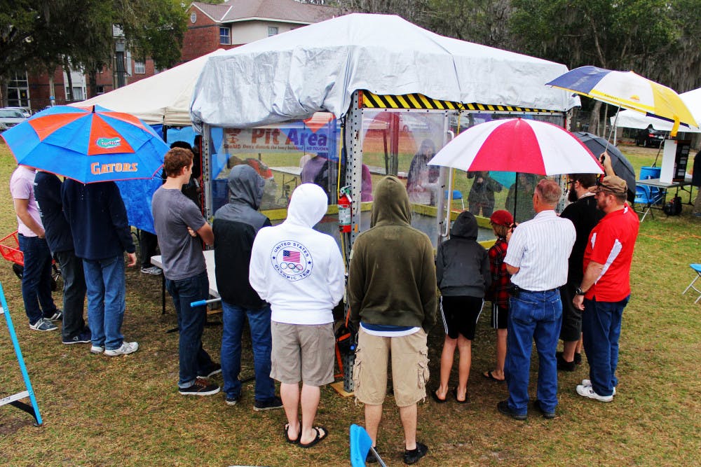 Attendees of the Engineering Festival crowd around a display area in the rain on Saturday. The group watched robots go head to head in what some called "combat robotics."