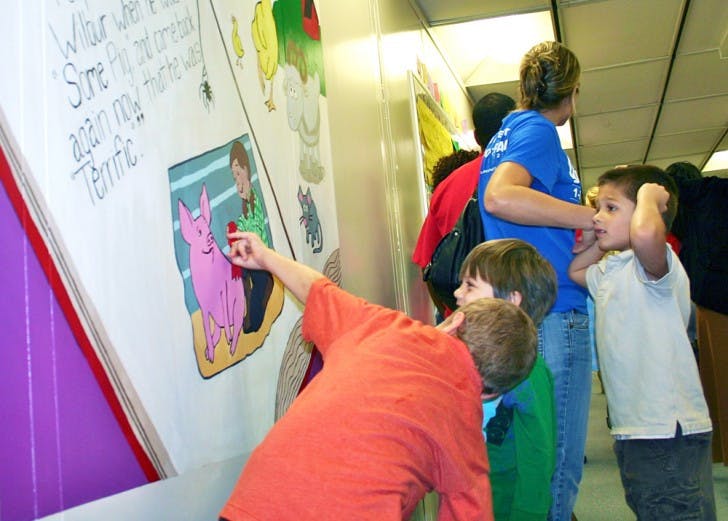 Chester Shell Elementary School students look at a new Charlotte's Webb mural on Monday. The mural was painted by UF students as a part of Project Makeover, an organization that fixes up one Alachua County school each year.