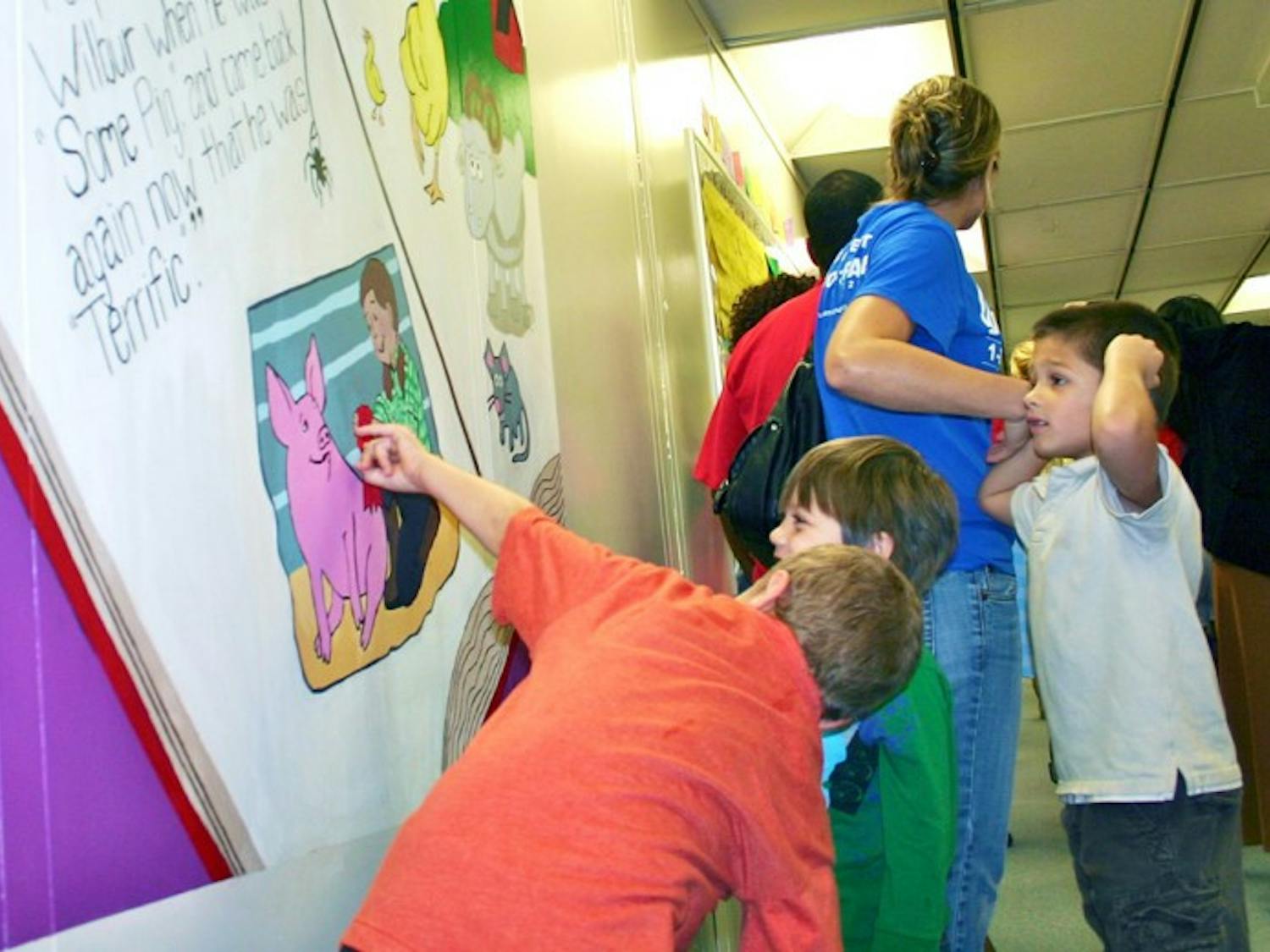 Chester Shell Elementary School students look at a new Charlotte's Webb mural on Monday. The mural was painted by UF students as a part of Project Makeover, an organization that fixes up one Alachua County school each year.