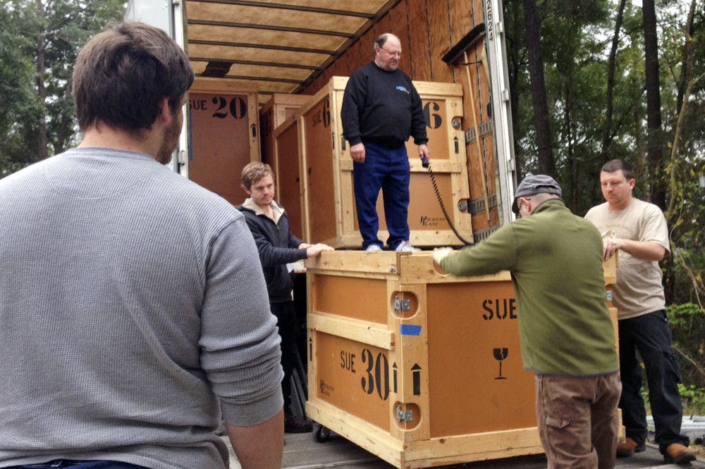 <p>Dale Neubauer, 65, supervises workers from the Florida Museum of Natural History and the Phillips Center for Performing Arts Center unload one of the crates in which Sue’s bones are packed. Each crate weighs about a ton.</p>