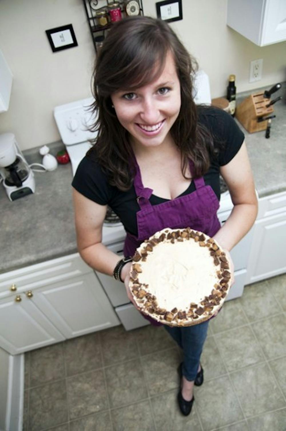 <p>Becca Goldring, 21-year-old UF student athlete on the Gators track and field team, holds up a peanut butter pie, a Becca Bakes treat she made for a friend's birthday.</p>