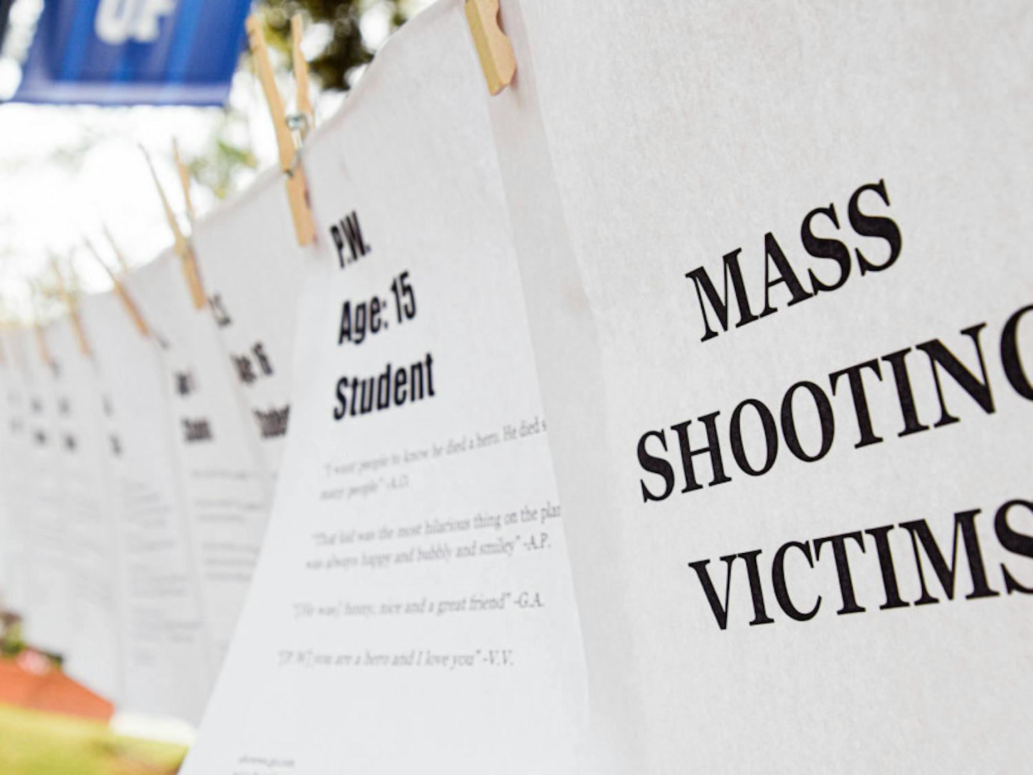 March For Our Lives Gainesville pins up pieces of paper with information about people who died in various mass shootings, such as their name, age and what they were like as told by loved ones.