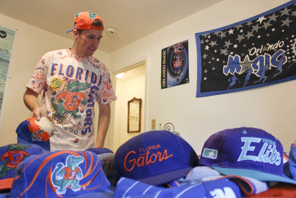<p>Josh Rittenour, a 20-year-old UF economics junior, lays out a portion of sports hats that he has collected through thrifting at his house on Sept. 24, 2015. Rittenour restores the old hats. “It’s something that I have and can bring back to life and let someone else enjoy as much as the original person,” he said.</p>