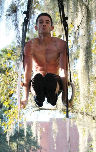 Michael Vigh, 21, practices gymnastics ring exercises for CrossFit training nera Gale Lemerand Drive and Museum Road on Tuesday evening.