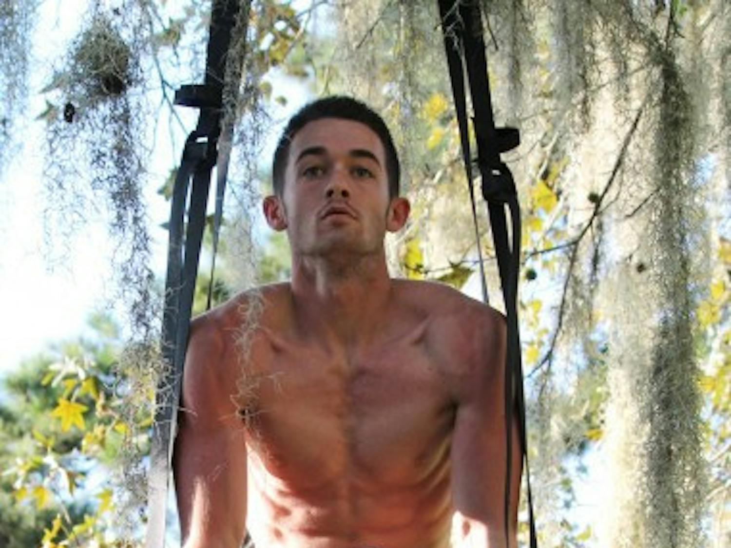 Michael Vigh, 21, practices gymnastics ring exercises for CrossFit training nera Gale Lemerand Drive and Museum Road on Tuesday evening.