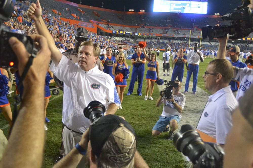 <p>Surrounded by media, Jim McElwain celebrates Florida's 61-13 win against New Mexico State on Sept. 5, 2015. This was his first game as head UF football coach.</p>