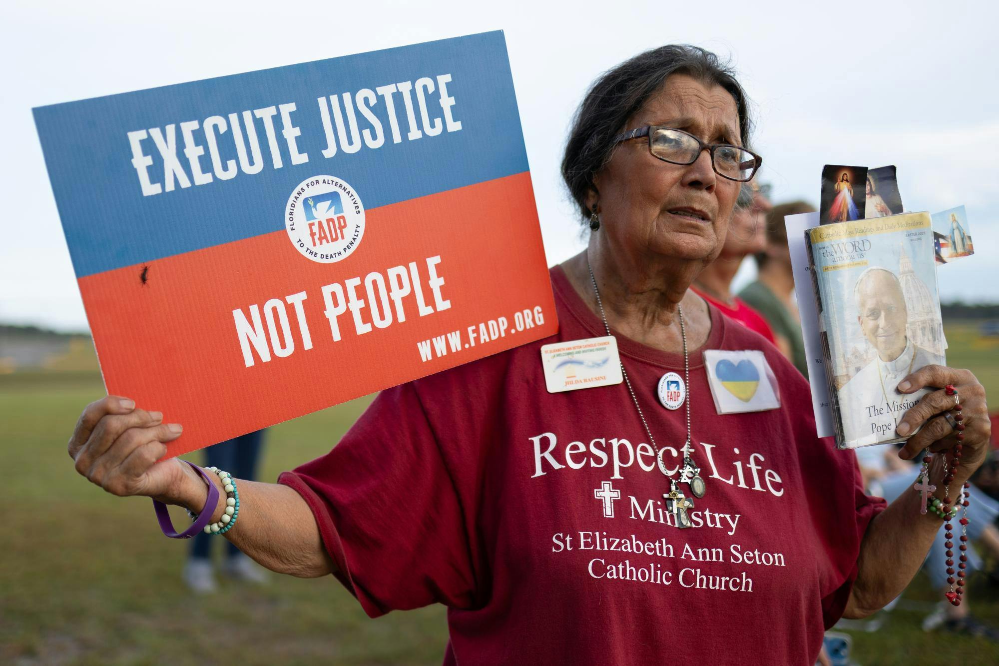 A protester holds a sign reading, “execute justice not people” and a book with Pope Leo XIV’s face during a demonstration against the death penalty outside the Florida State Prison, Tuesday, Sept. 29, 2026, in Raiford, Fla.