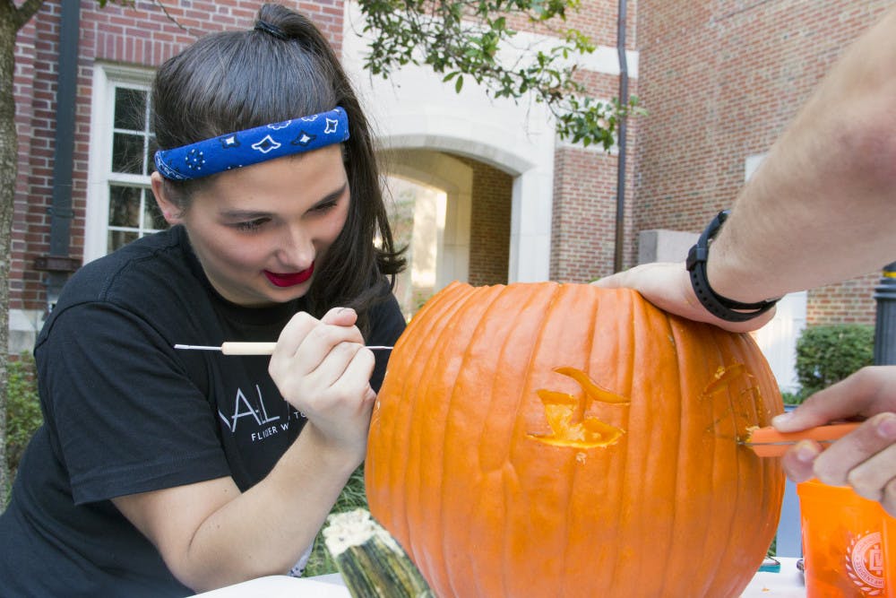 Rhyan Nedobity, a 19-year-old UF accounting sophomore, carves a pumpkin monday during the Pumpkin Palooza Leadership Venture at the Heavener Hall courtyard. Hosted by the Warrington Diplomats, the organization holds events that focus on professional development every semester.