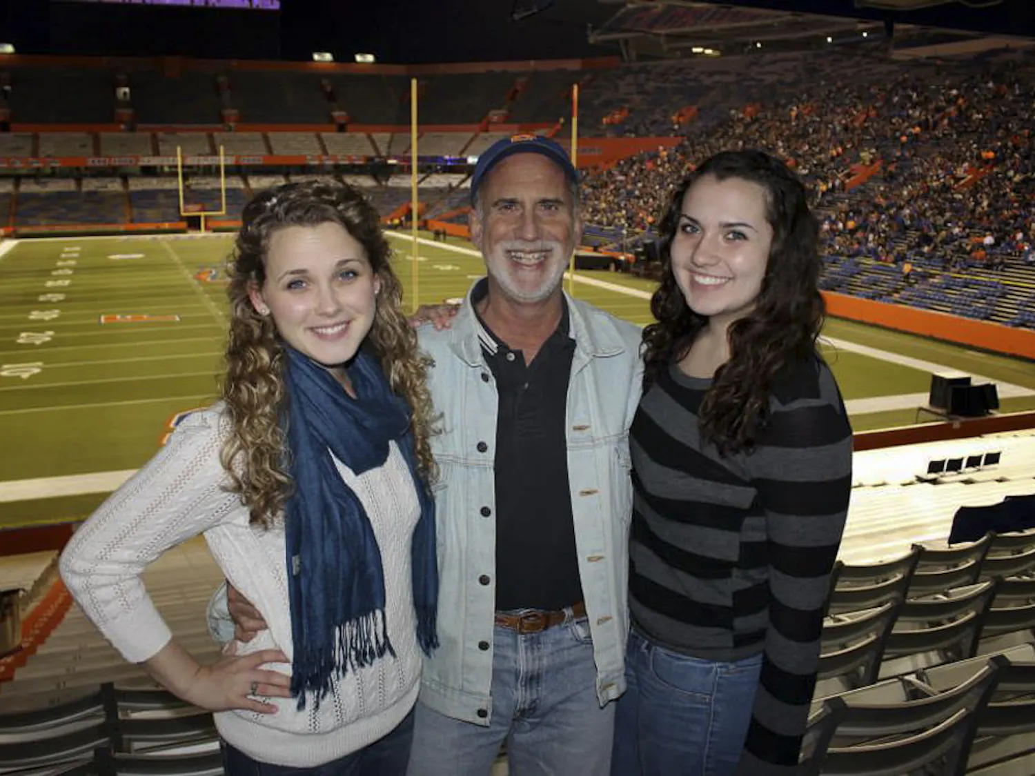 Karl Kaufmann poses with his daughters Kelli, left, 20, and Kaitlyn, 16, in Ben Hill Griffin Stadium during Gator Growl on Nov. 9, 2013. The 59-year-old has been the announcer for Gator Growl since 1980.